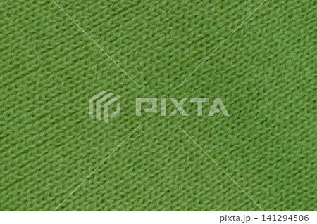 Horizontal close up of a bright green knitted wool fabric showing a neat diagonal ribbed texture on a warm winter clothing background Horizontal close up of a bright green knitted wool fabric showing a neat diagonal ribbed texture on a warm winter clothing background 141294506
