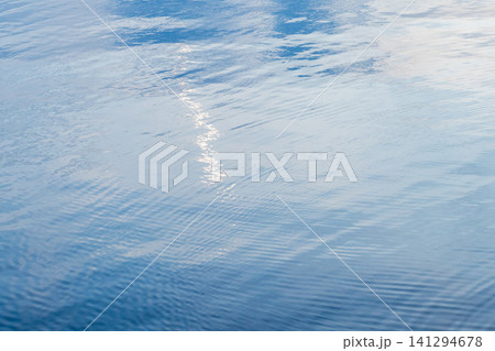 Shiny blue still water surface with smooth ripples Shiny blue still water surface with smooth ripples 141294678