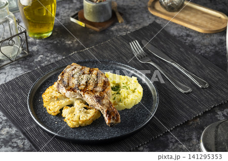 Grilled pork chop with mashed potatoes and cauliflower steak 141295353