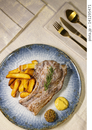 Pork chop dinner with golden fries and mustard Pork chop dinner with golden fries and mustard 141295471