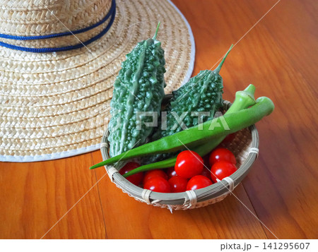 家庭菜園で収穫した新鮮な夏野菜と麦わら帽子 141295607