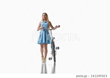 Woman standing with city bicycle on white studio background. Woman standing with city bicycle on white studio background. 141295923