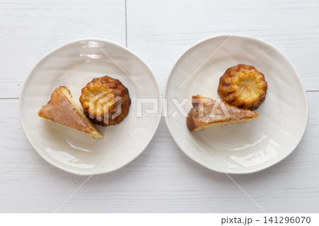 白い皿に並んだ手作りのカヌレとケーキ 白い皿に並んだ手作りのカヌレとケーキ 141296070