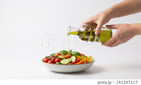Pouring extra virgin olive oil over fresh vegetable salad with vegetables dressing nutrition vegetarian ingredients culinary homemade tomatoes cucumbers prepared delicious wholesome Pouring extra virgin olive oil over fresh vegetable salad with vegetables dressing nutrition vegetarian ingredients culinary homemade tomatoes cucumbers prepared delicious wholesome 141297227