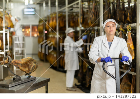 Woman with a pallet truck in a jamon factory Woman with a pallet truck in a jamon factory 141297522