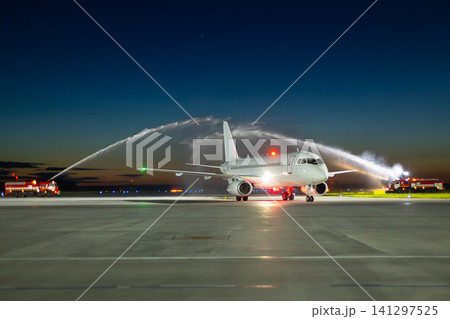 Water arch for first visit white passenger plane at the night airport Water arch for first visit white passenger plane at the night airport 141297525