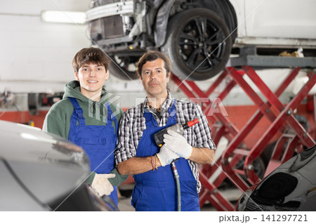 Guy and man mechanics posing in car repair shop 141297721