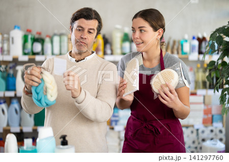 Saleswoman offers man to buy body washcloth in supermarket Saleswoman offers man to buy body washcloth in supermarket 141297760