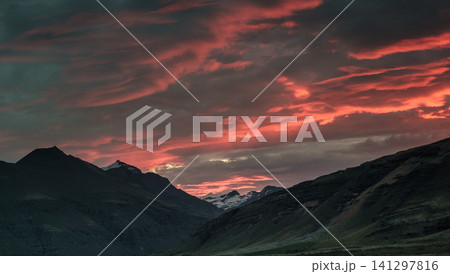 Fiery red and pink clouds during a stunning sunset over Hornafjordur, south Iceland. Fiery red and pink clouds during a stunning sunset over Hornafjordur, south Iceland. 141297816