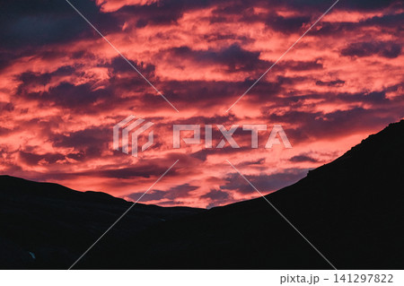Fiery red and pink clouds during a stunning sunset over Hornafjordur, south Iceland. Fiery red and pink clouds during a stunning sunset over Hornafjordur, south Iceland. 141297822