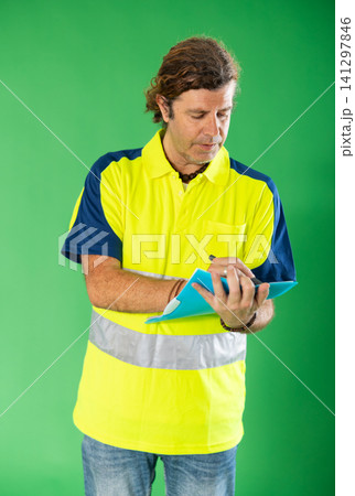 Man in reflective polo on green screen background with paper inventory form Man in reflective polo on green screen background with paper inventory form 141297846