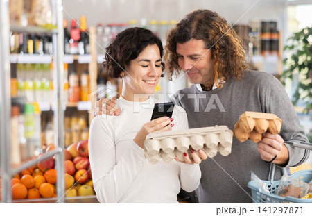 Woman and man scanning eggs in store Woman and man scanning eggs in store 141297871
