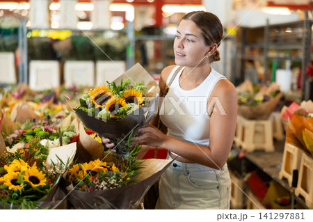 Young woman choosing bouquet of flowers Young woman choosing bouquet of flowers 141297881