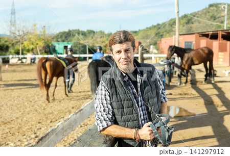 Portrait of confident farm owner in front of his stable Portrait of confident farm owner in front of his stable 141297912