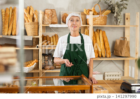 Mature saleswoman stands in bake house welcoming clients 141297990