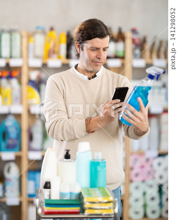 Middle-aged man scanning spray barcode in store Middle-aged man scanning spray barcode in store 141298052