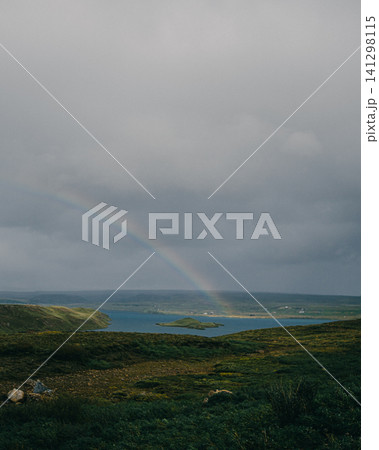 Rainbow over a scenic lake and lush green landscape in Thingvellir, Iceland. 141298115