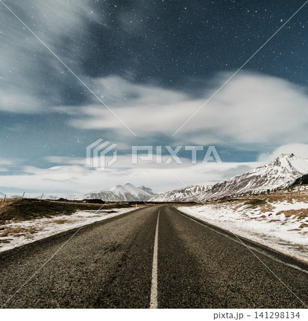 Starry night over a snow-lined road leading to rugged mountains in Hornafjordur, south Iceland. Starry night over a snow-lined road leading to rugged mountains in Hornafjordur, south Iceland. 141298134