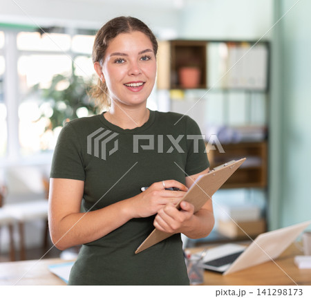 Young woman conducting survey with clipboard in office Young woman conducting survey with clipboard in office 141298173