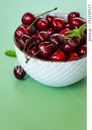 Seasonal sweet cherries in ceramic bowl on soft pastel background Seasonal sweet cherries in ceramic bowl on soft pastel background 141298527
