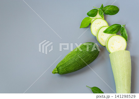 Fresh zucchini with sliced courgette on gray background with basil 141298529