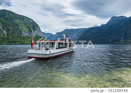 Passenger boat cruising on a mountain lake, illustrating a vacation in the Austrian Alps with a scenic summer atmosphere. 141298548