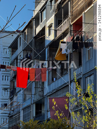 Sunlit balconies with colorful laundry hanging on old residential buildings in Batumi, Georgia Sunlit balconies with colorful laundry hanging on old residential buildings in Batumi, Georgia 141298894