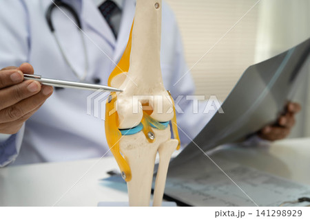 Doctor examining knee joint bone radiography xray film. Doctor examining knee joint bone radiography xray film. 141298929