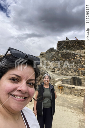 Women taking selfie overlooking Ollantaytambo town. UGC 141299125
