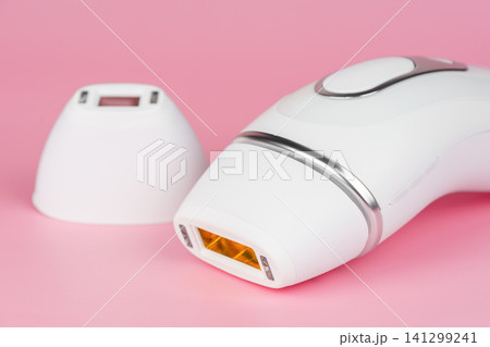 Modern white IPL photoepilator and attachment precision on pink background, beauty device Modern white IPL photoepilator and attachment precision on pink background, beauty device 141299241