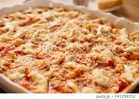 Gnocchi in tomato sauce topped with mozzarella and grated cheese in baking dish Gnocchi in tomato sauce topped with mozzarella and grated cheese in baking dish 141299352