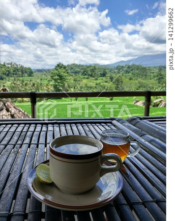 A mug of tea on a beautiful tropical background of rice fields A mug of tea on a beautiful tropical background of rice fields 141299662