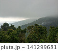 Lush green tropical mountains with a rain cloud at the peak. 141299681