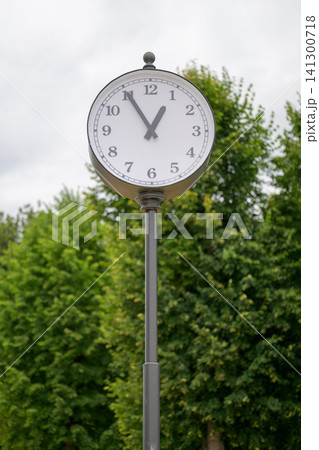 White clock face on tall metal pole White clock face on tall metal pole 141300718