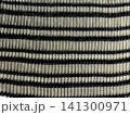macro view of cozy ribbed knit fabric texture with black and cream horizontal stripes for textile design and fashion backgrounds 141300971