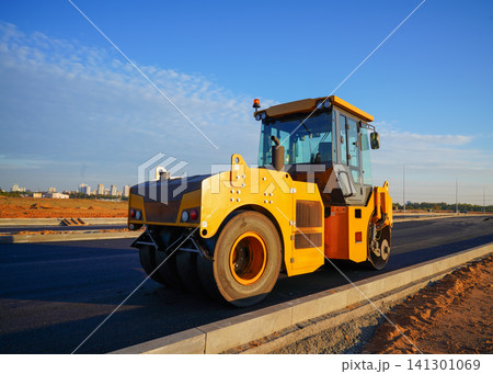 Asphalt road construction. Vibrator compactor machine on roadworks, asphalt pavement Asphalt road construction. Vibrator compactor machine on roadworks, asphalt pavement 141301069