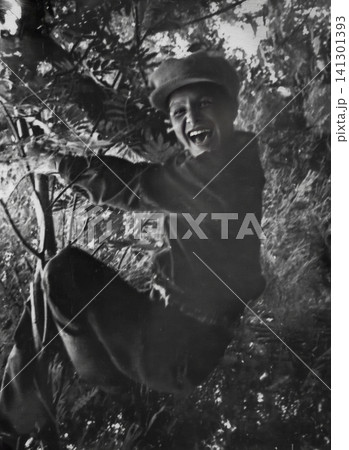 Smiling Soviet Boy Climbing a Tree in Autumn Smiling Soviet Boy Climbing a Tree in Autumn 141301393