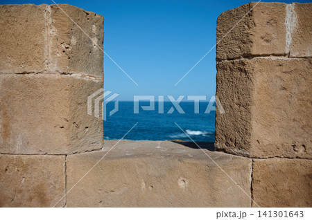 Stone battlement window framing Atlantic sea view in Essaouira old medina Stone battlement window framing Atlantic sea view in Essaouira old medina 141301643