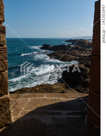 Ocean view from stone arch in Essaouira medina, Morocco overlooking rocky coastline Ocean view from stone arch in Essaouira medina, Morocco overlooking rocky coastline 141301647