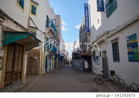 Quiet street in Essaouira old Medina with blue shutters and a parked bicycle Quiet street in Essaouira old Medina with blue shutters and a parked bicycle 141301675