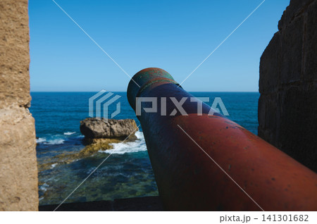 Historic cannon overlooking Atlantic Ocean from Essaouira medina fortress with old city walls and rocky coast Historic cannon overlooking Atlantic Ocean from Essaouira medina fortress with old city walls and rocky coast 141301682