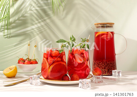 Refreshing summer homemade lemonade cocktail and non-alcoholic mojito, strawberry iced tea with berries, mint and lemon, weight loss concept, detox water with fruit flavor on light background. Refreshing summer homemade lemonade cocktail and non-alcoholic mojito, strawberry iced tea with berries, mint and lemon, weight loss concept, detox water with fruit flavor on light background. 141301763