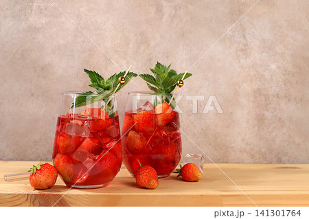 Refreshing summer homemade lemonade cocktail and non-alcoholic mojito, strawberry iced tea with berries, mint and lemon, weight loss concept, detox water with fruit flavor on light background. healthy Refreshing summer homemade lemonade cocktail and non-alcoholic mojito, strawberry iced tea with berries, mint and lemon, weight loss concept, detox water with fruit flavor on light background. healthy 141301764