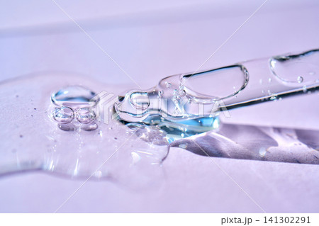 Cosmetic serum liquid flowing from pipette with bubbles 141302291