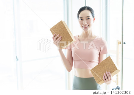 ヨガブロックを持つ女性 インストラクター ヨガブロックを持つ女性 インストラクター 141302308
