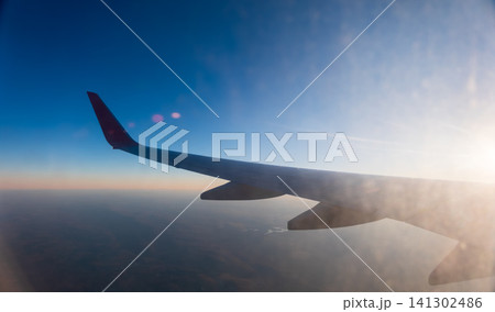 View on sunset and airplane wing from the inside 141302486