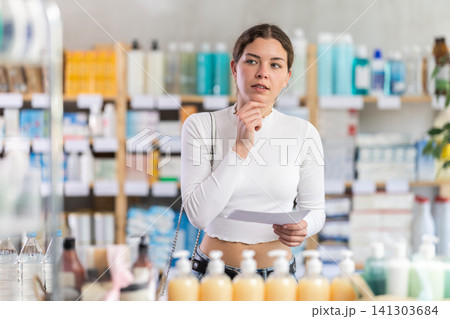 Woman with a medical prescription being examined at a pharmacy Woman with a medical prescription being examined at a pharmacy 141303684