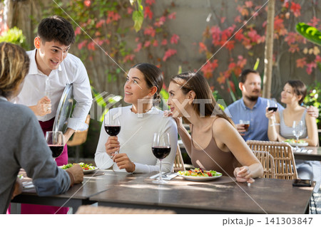 Waiter talking to restaurant guests - taking orders for food and drinks 141303847