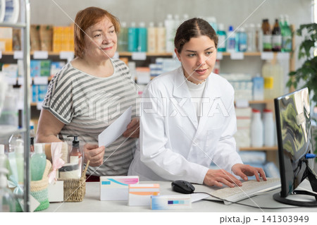 Woman pharmacist looking for prescription on computer for buyer 141303949