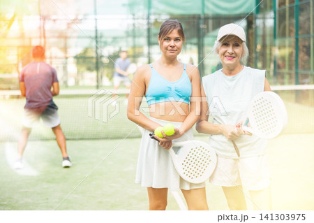 Female tennis players standing on outdoor court after game Female tennis players standing on outdoor court after game 141303975